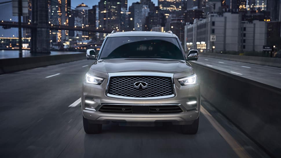 Front view of 2024 INFINITI QX80 SUV driving down city street